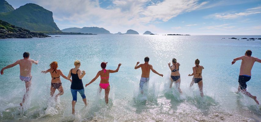 acht Menschen rennen ins Meer