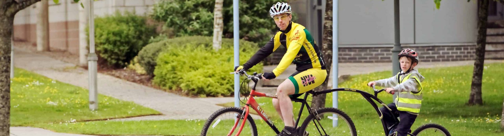 Mann auf Fahrrad mit Kind auf Fahrrad