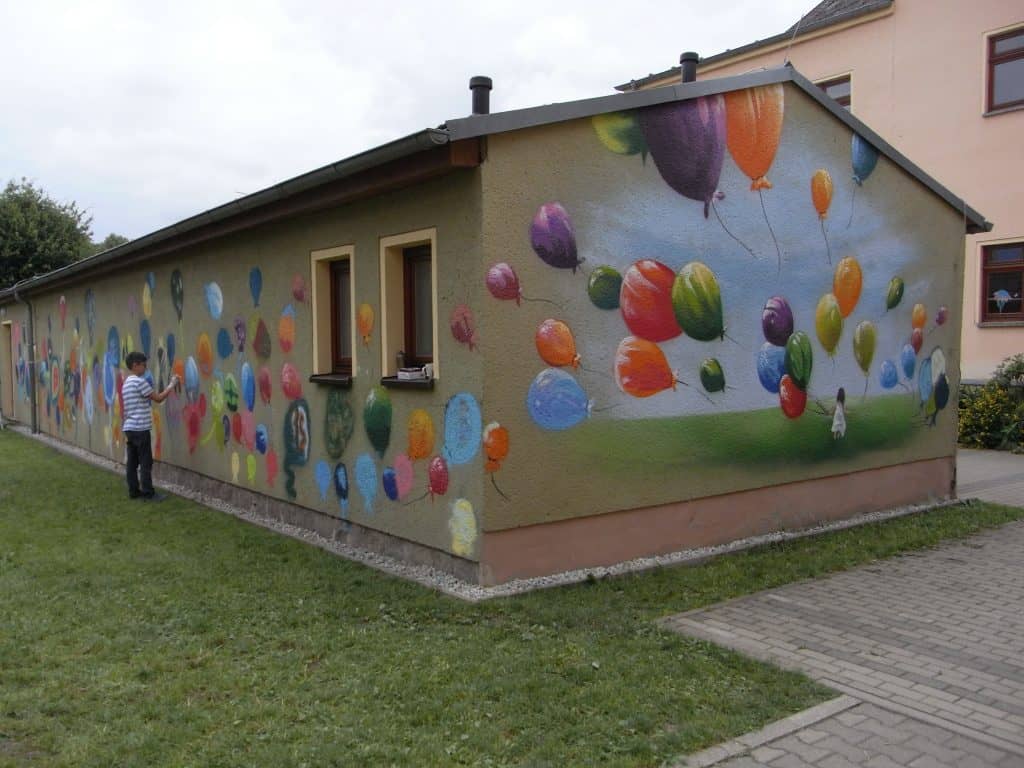 Bunte Ballons auf trister Fassade