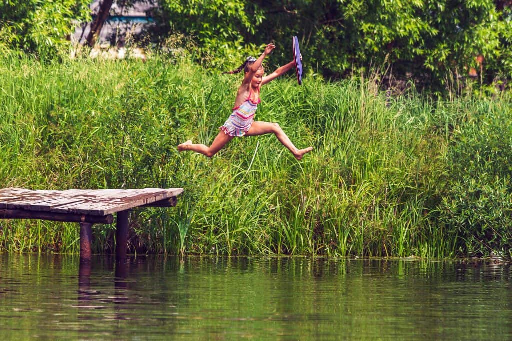 Mädchen springt in einen See
