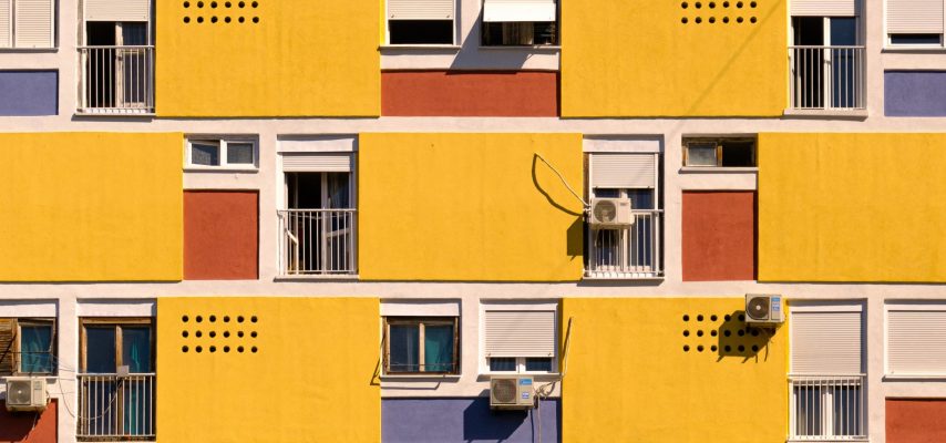 gelbes Haus mit Klimaanlagen an den Fenstern