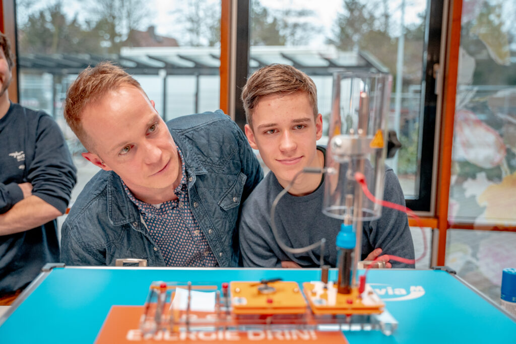Wasserstoff-Experimentierkoffer, Mitarbeiter und ihre Kinder experimentieren gemeinsam mit enviaM-CEO Stephan Lowis