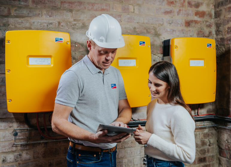 Fachhandwerker und Kundin im Gespräch zum Sunny Island Batterie-Wechselrichter von SMA.