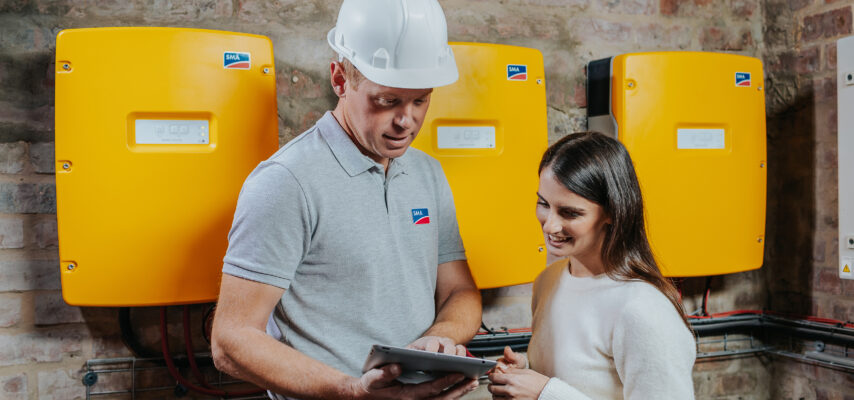 Fachhandwerker und Kundin im Gespräch zum Sunny Island Batterie-Wechselrichter von SMA.