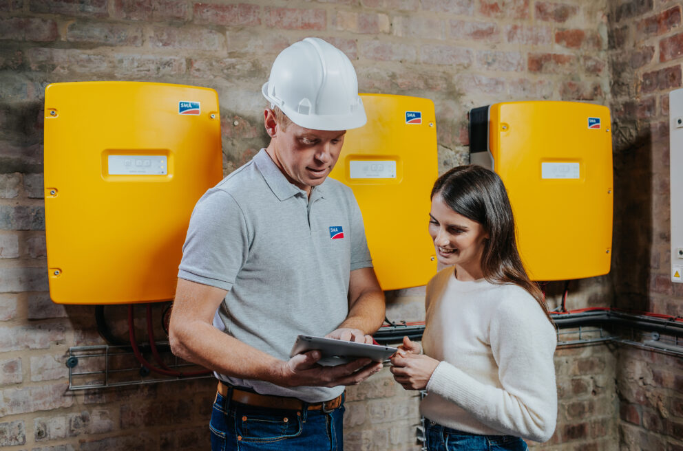 Fachhandwerker und Kundin im Gespräch zum Sunny Island Batterie-Wechselrichter von SMA.