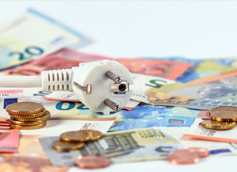 Ein Stecker liegt auf Geldscheinen und Münzen