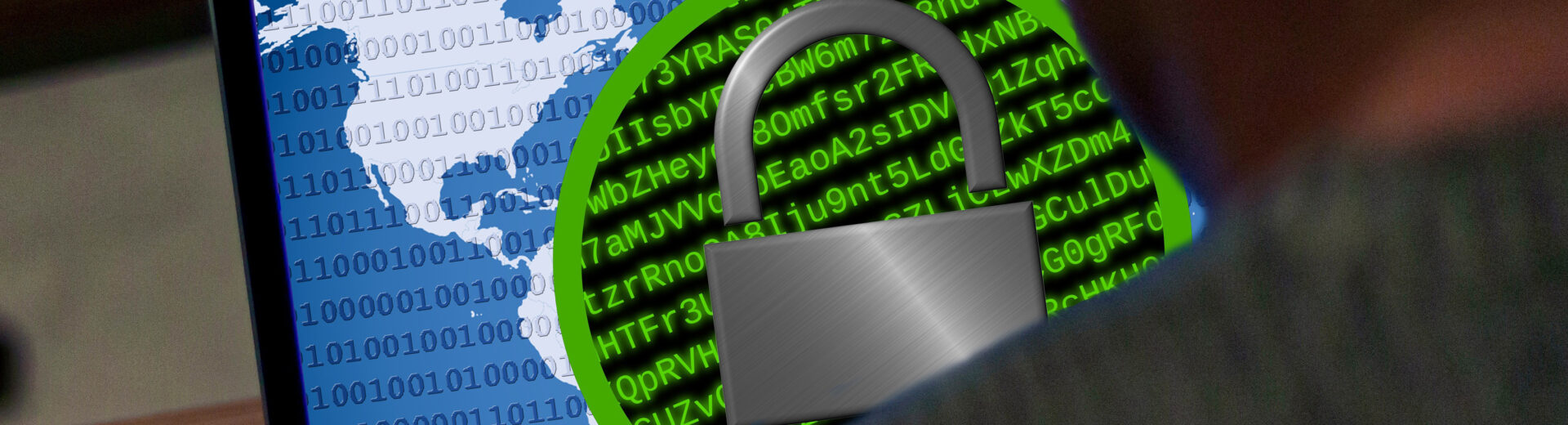 Laptopbildschirm mit Weltkarte, Binärcode und großem Vorhängeschloss-Symbol vor grünem Codehintergrund, Person im Vordergrund.