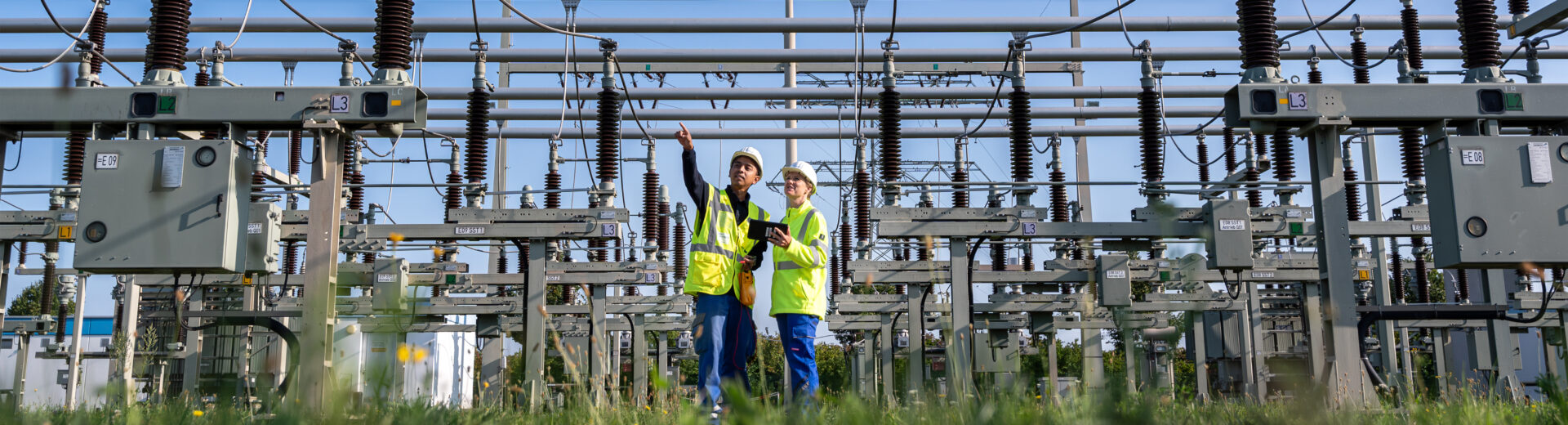 zwei Mitarbeitende von MITNETZ STROM bei Arbeiten in einem Umspannwerk