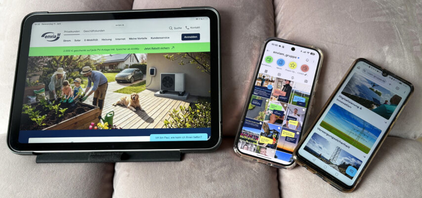 Drei Geräte auf einem Sofa: links ein Tablet mit einer Website über Solar/Heizung (Familie im Garten), daneben zwei Smartphones mit Social-Media- und Info-Seiten.